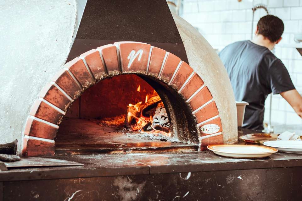Hombre de pie junto a la chimenea mirando hacia atrás